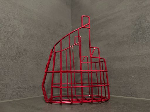 Rote Drahtskulptur in geometrischer Form vor einem grauen Hintergrund.